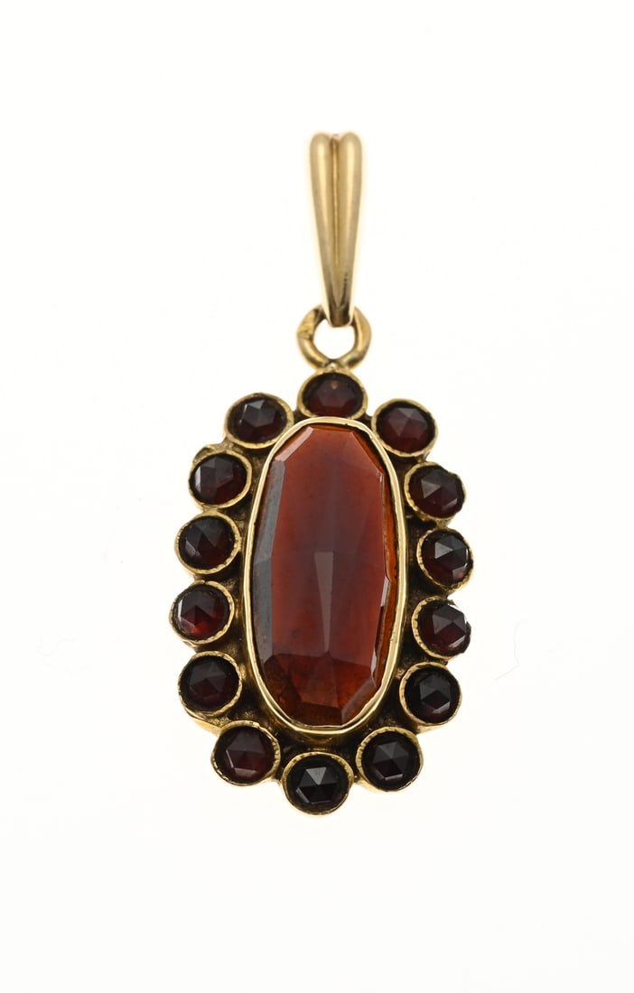 Gold pendant with garnet: Yellow gold pendant, 585/000, with garnet. Pendant with oval rosette set with an oval faceted garnet and 14 round faceted garnets. Length 3.5cm. approx. 3.9 grams. In good condition.