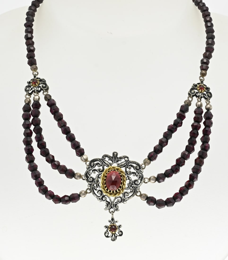 Choker with garnet and silver: Choker with garnet stones with a silver element in the middle, 835/000, with a floral shape with gold-plated elements set with a garnet stone. Next to the silver element are 2 silver floral elements w