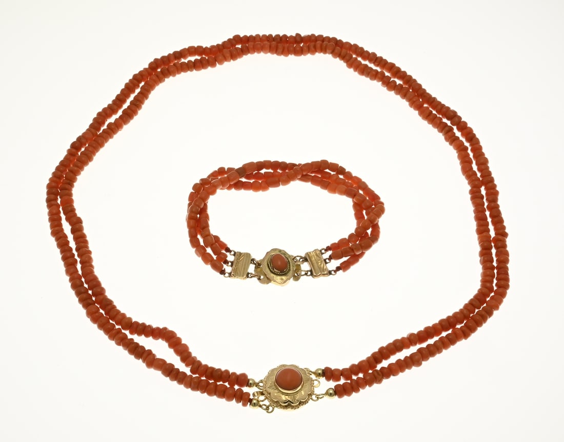 Necklace & bracelet of red coral with gold clasp: Necklace and bracelets of blood corals with gold clasps, 585/000. Necklace of 2 rows of blood coral, ø 4.6 mm., attached to a round yellow gold clasp with decorated edge and a blood coral. length 42