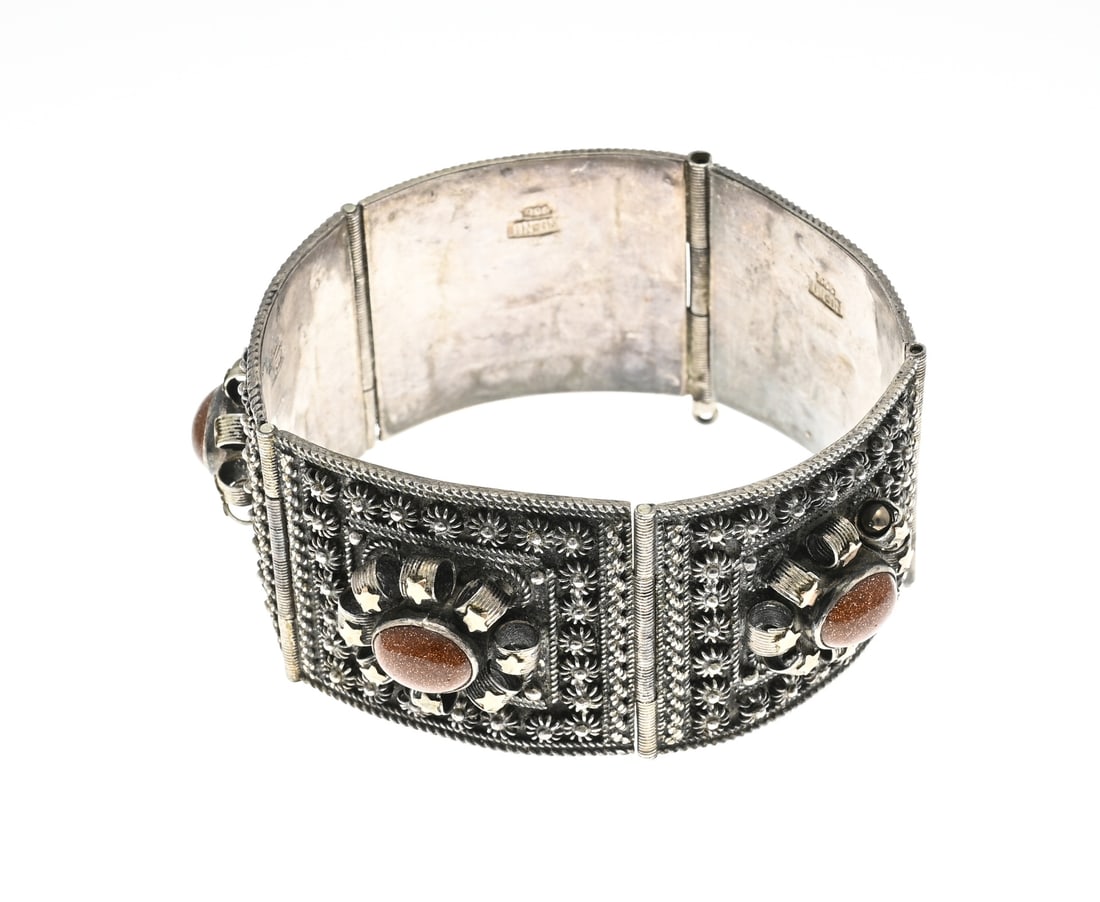 Silver bracelet with goldstone: Wide silver bracelet, 900/000, with goldstone. Bracelet with square links decorated with buttons and a rosette with soldered gold-plated star elements and in the middle an oval cabochon cut