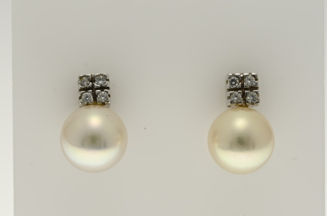 White gold stud earrings with pearl: White gold stud earrings, 750/000, with pearl and zirconia. Stud earrings with a cultured pearl, ø 7.5 mm. and a square white gold element with 4 zirconia. 11.2 mm. approx. 2.9 grams. In good