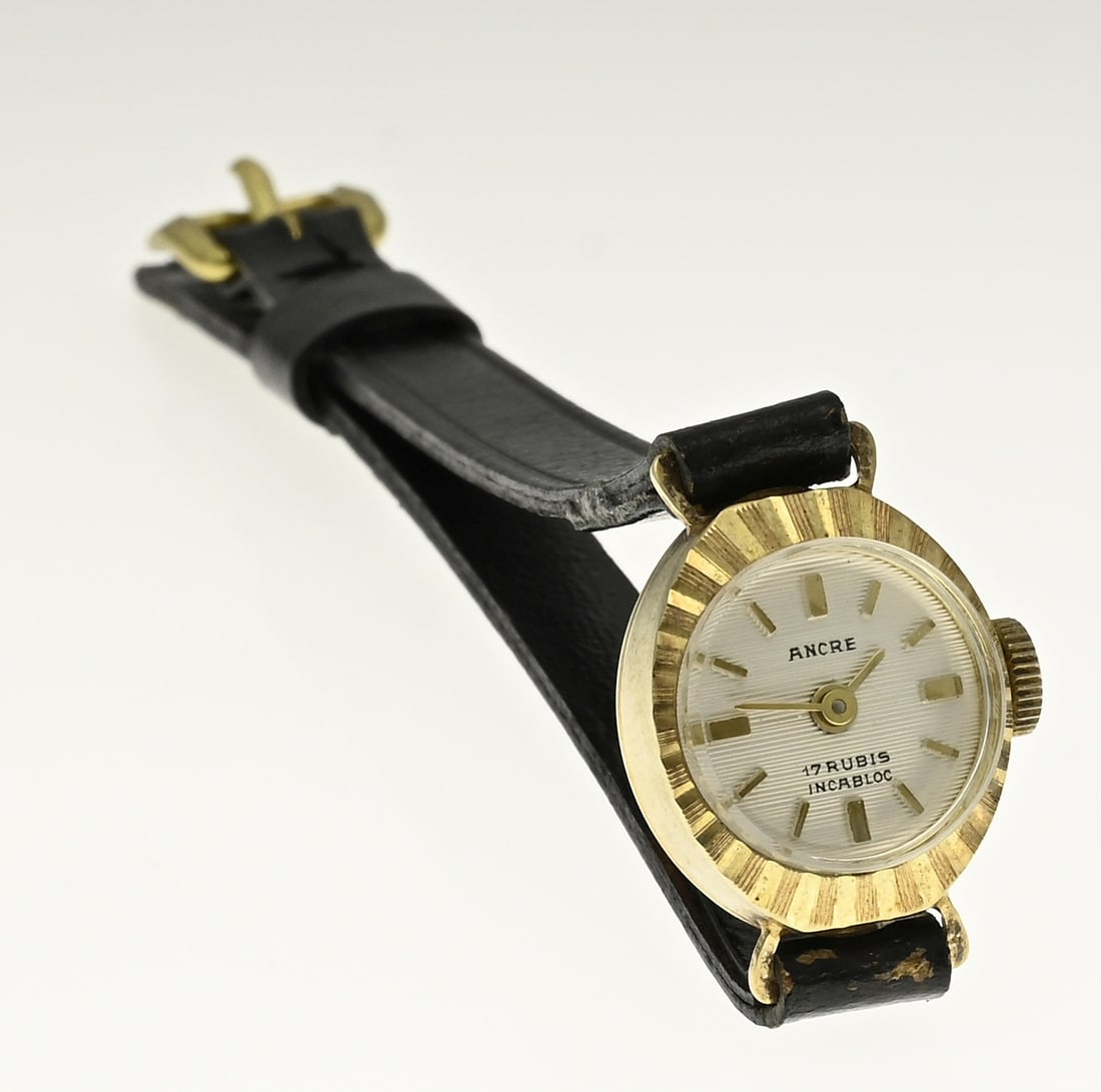 Gold watch with leather strap: Yellow gold ladies watch, 585/000, with a leather strap. Oval shaped watch case with a facetted finish. 14x17mm. Mechanical, Ancre. Unworn, working.