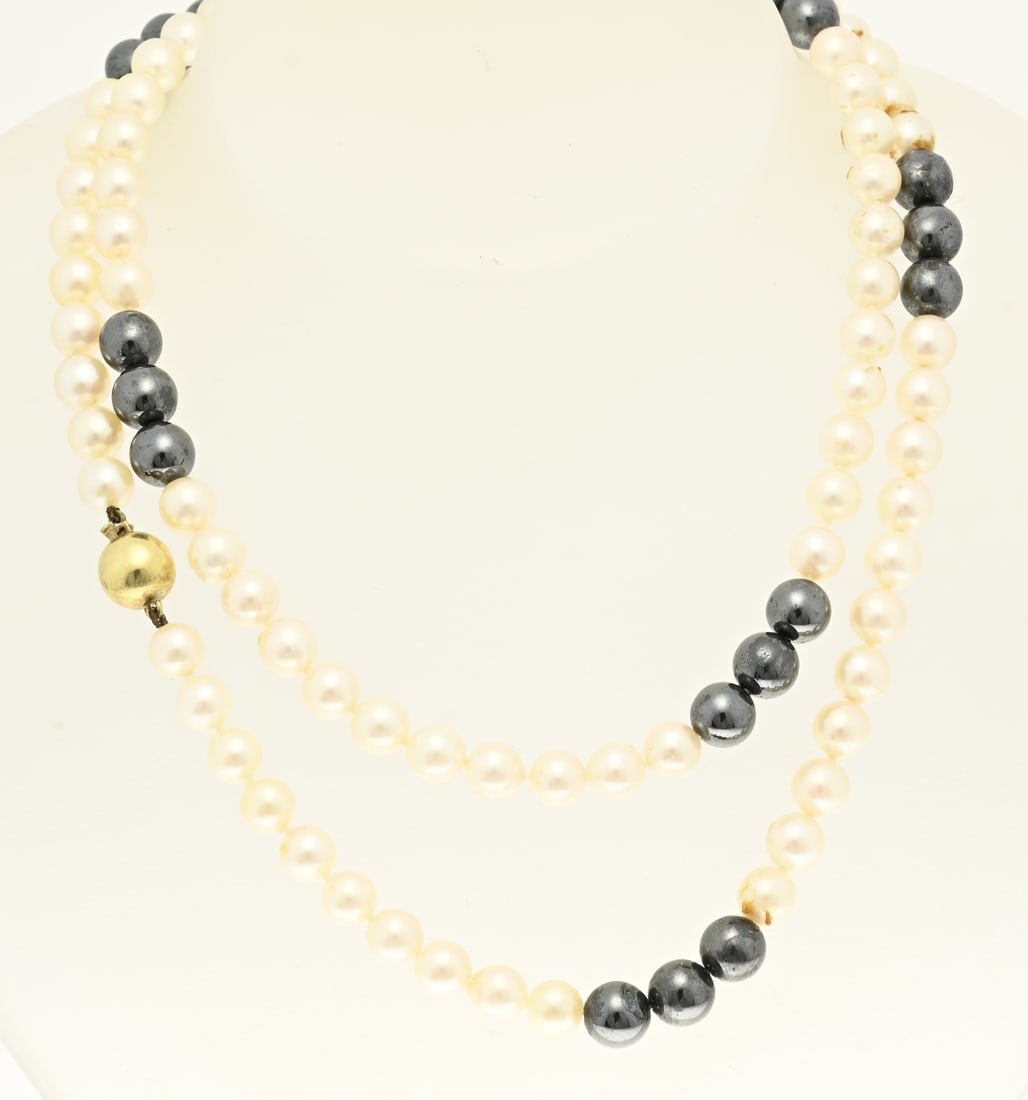 Necklace with pearls and hematite and gold: Necklace with cultured pearls, ø 6.5 mm., and hematite beads, ø 8 mm., attached to a yellow gold ball clasp, 585/000. ø 9.5 mm. Length 75 cm. In good condition.