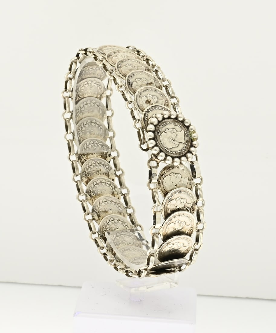 Willem III coin bracelet: Silver bracelet made of 26x 5 cent coins, Willem III, king, of the Dutch East Indies. Width 21 mm. Length 21 cm. Approx. 28 grams. In good condition.