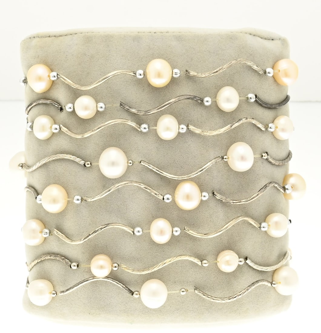 Lot of bracelets with silver and pearls, 8x: Lot with bracelets with silver curved elements and freshwater pearls. The bracelets are strung on elastic. approx. 36 grams. In good condition.
