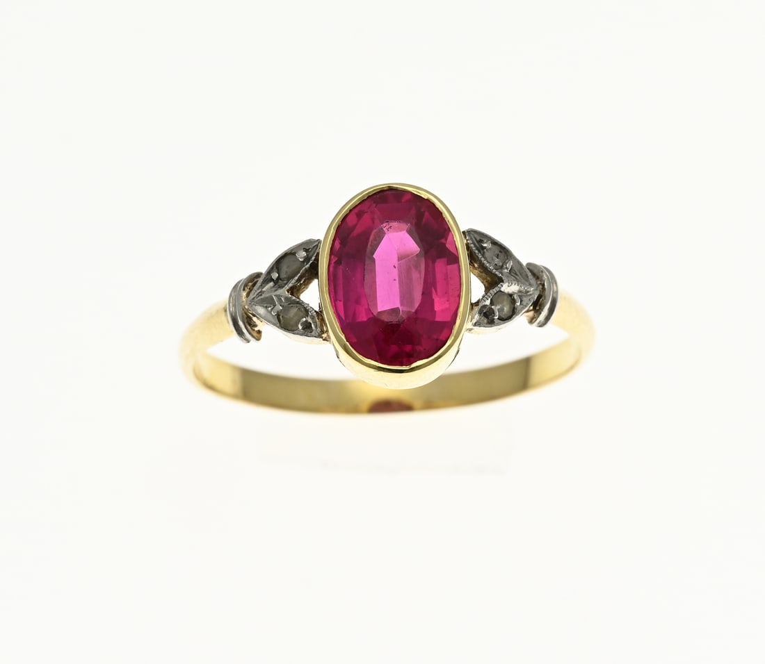 Gold ring with ruby: Yellow gold ring, 585/000, with ruby and diamonds. Ring with an oval setting with an oval faceted ruby. On either side of the ruby 2 leaf-shaped elements set with a diamond. Width ring 9 mm. ø 53.