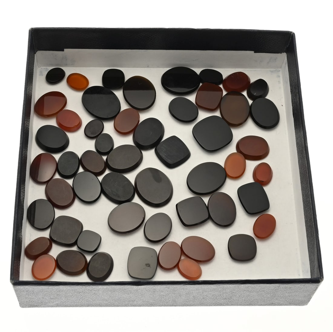 Lot of precious stones carnelian and onyx.: Large lot with approx. 50 carnelians and onyx. Flat oval, rectangular and square cut stones. approx. 33 grams. New.