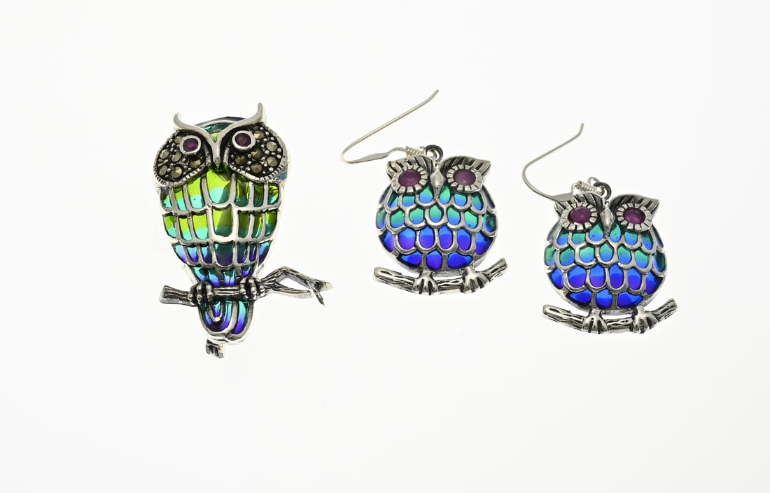 Silver brooch and earrings, owl enamel: Silver brooch and earrings, 925/000, in the shape of an owl decorated with enamel, marcasite and rubies. 35 mm. total approx. 13.6 grams. In very good condition.