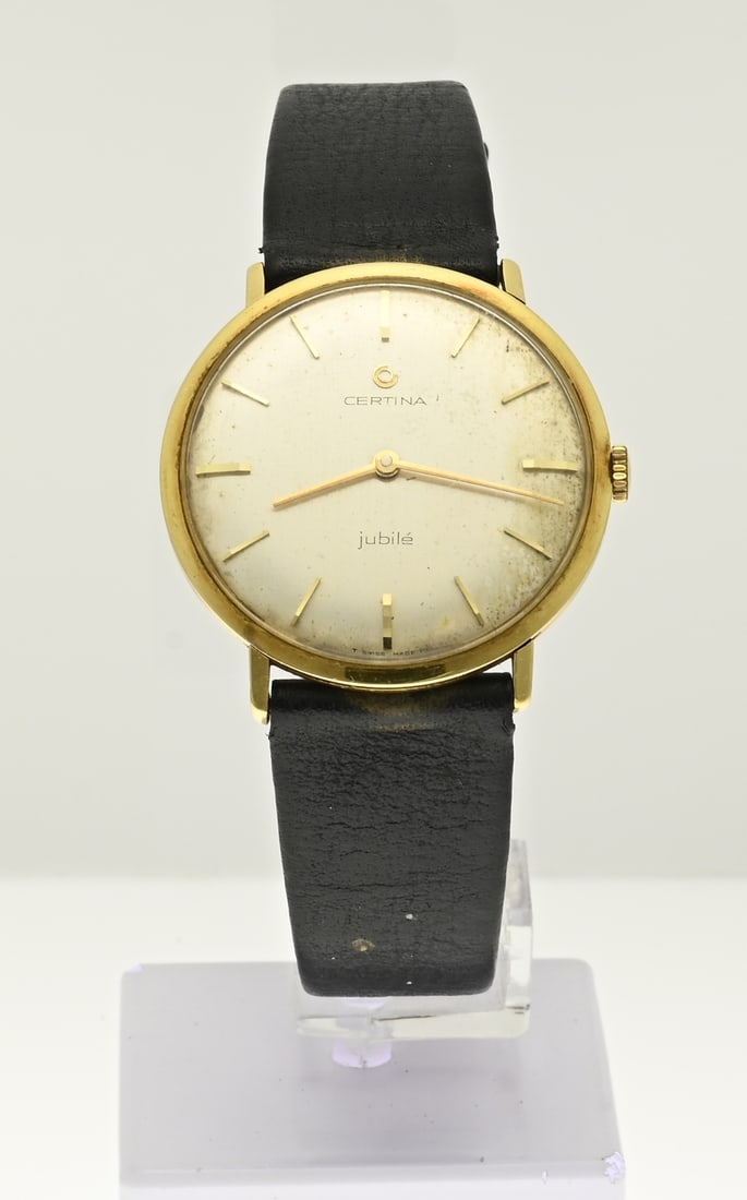 Certina watch, 18 kt: Vintage gold Certina jubilee watch, 750/000, unisex. ø 34 mm. The back cover is provided with an engraving: 1919-1969 KNZ. Attached to a black leather strap. Working. Dial somewhat affected.