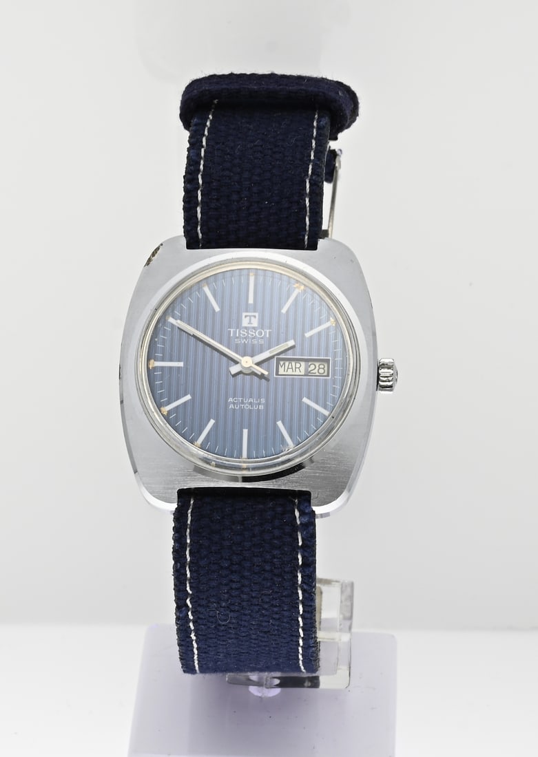 Tissot watch, blue: Tissot watch, mechanical, actualis autolub, with a square contoured case provided with a blue worked dial with day and date indication, attached to a blue strap. Case width ref. no.: 83501-3. In good