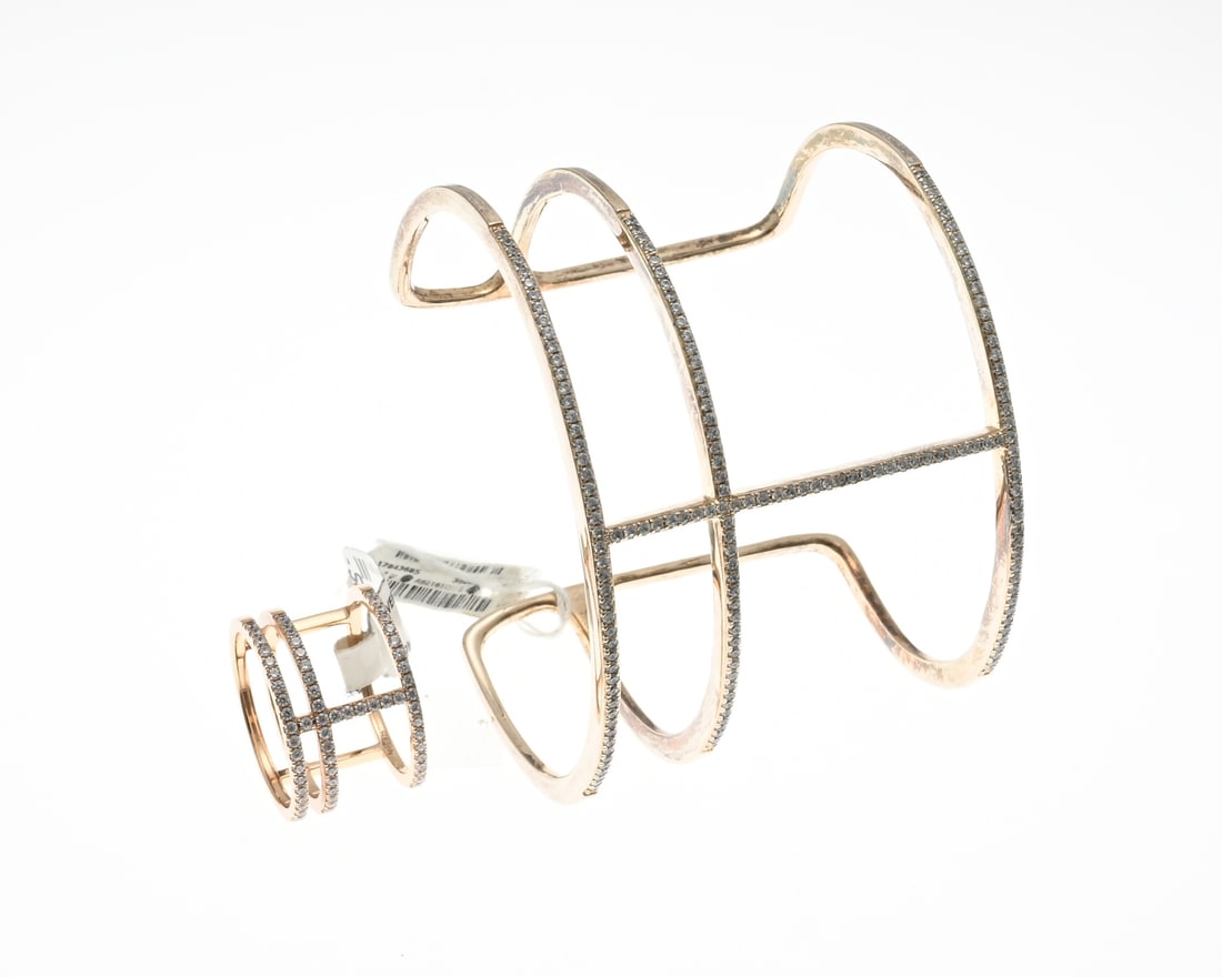 Bangle and ring rose gold plated with zirconias: Bangle and ring rose gold plated silver, 925/000, with zirconia. Open Bangle with 3 bands and a connecting bar, front completely set with zirconia. And a matching ring. ø 56, Width 14 mm. 46x58mm, wi