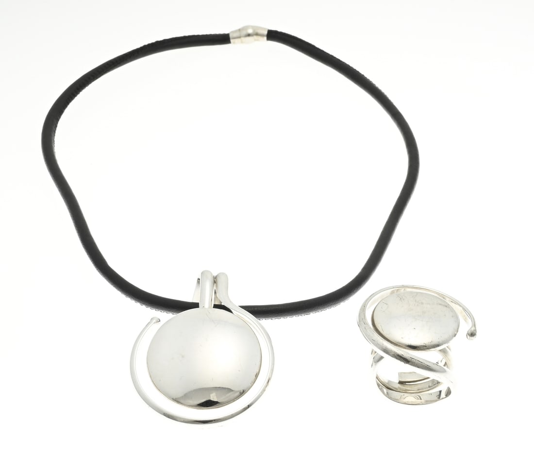 Silver set with choker and ring: Silver pendant and ring, 925/000, with a sleek round finish. ø pendant 4-5cm. attached to a leather cord. ø head of the ring 3 cm. ø 55. Total approx. 40 grams. In good condition.