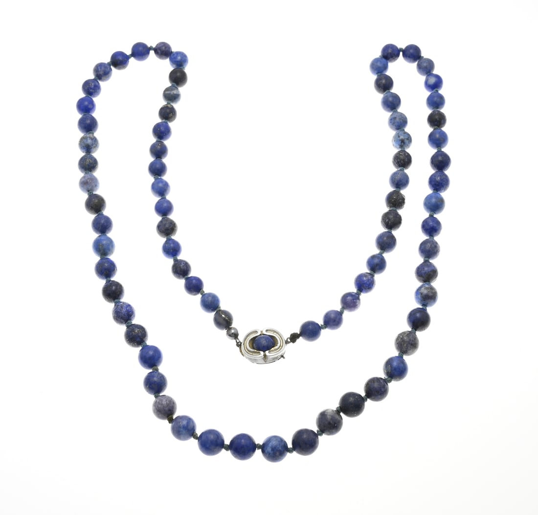 Lapis lazuli necklace: Long necklace with lapis lazuli beads, ø 8.5 mm, knotted. Fitted with an oval silver clasp with bead, 925/000. Length approx. 80 cm. In good condition.