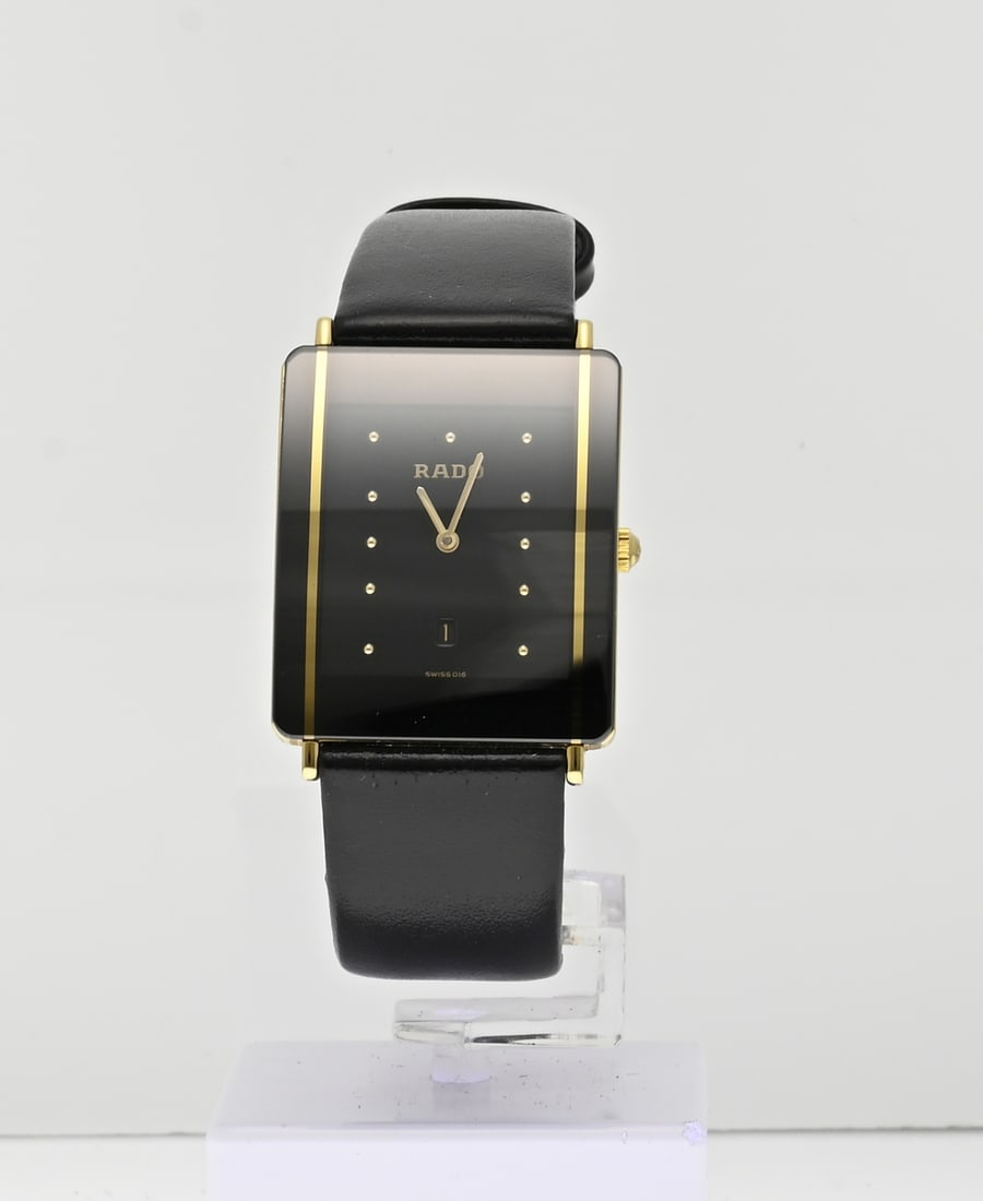 Rado watch, leather strap: Rado watch, Diastar, rectangular model, ceramic with gold lines, fitted with a black leather strap. Width 27 mm. Quartz. 04455568. In good condition.