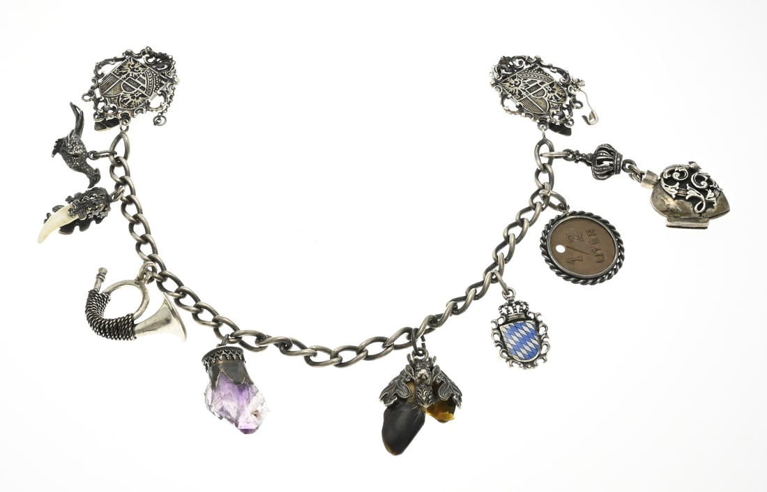 Silver necklace with hunting trophy: Silver trouser chain, 800/000, with gourmet links decorated with 2 clamps with coat of arms representation, and various charms including a pheasant, heart-shaped medallion, coat of arms and pendant