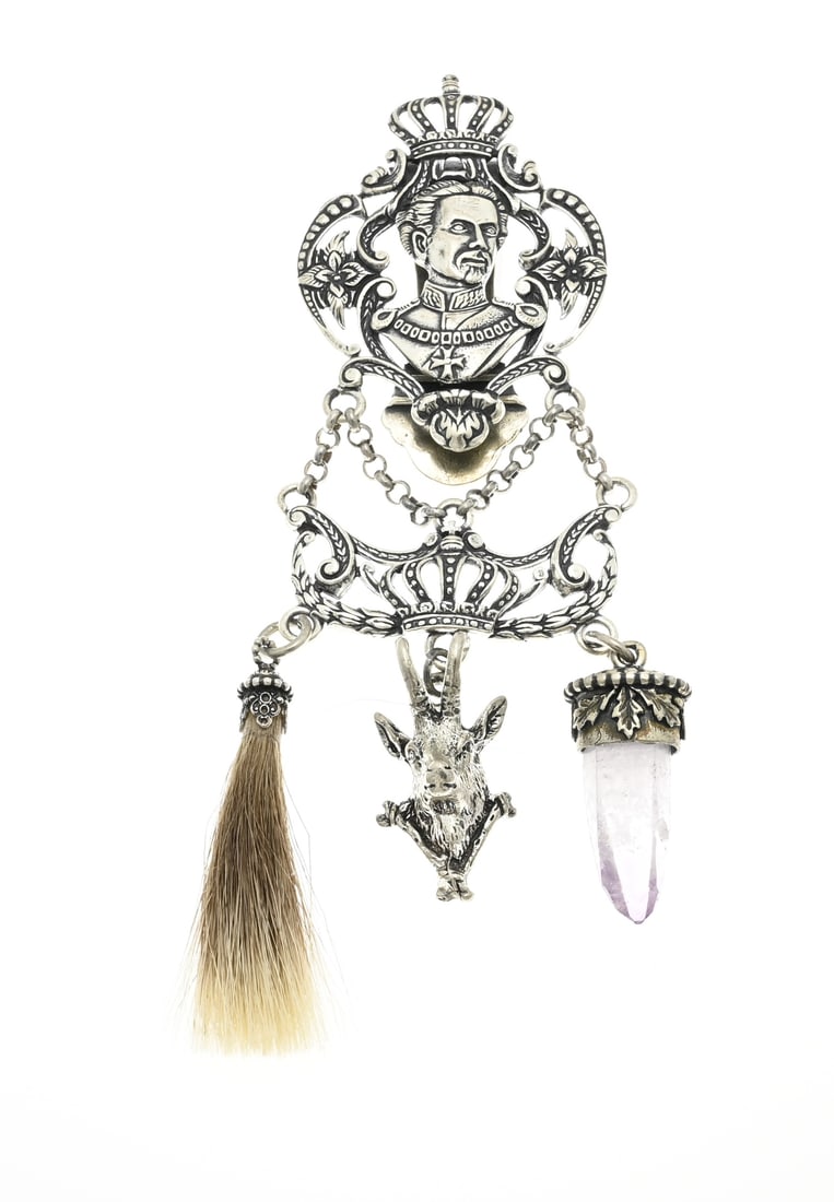 Silver trouser hook with hunting trophy: Silver trouser hook, 800/000, contoured model with crown and figure. The trouser hook has 3 pendants, one with amethyst, one with a piece of hair and one in the shape of a deer head. 14 cm. approx.