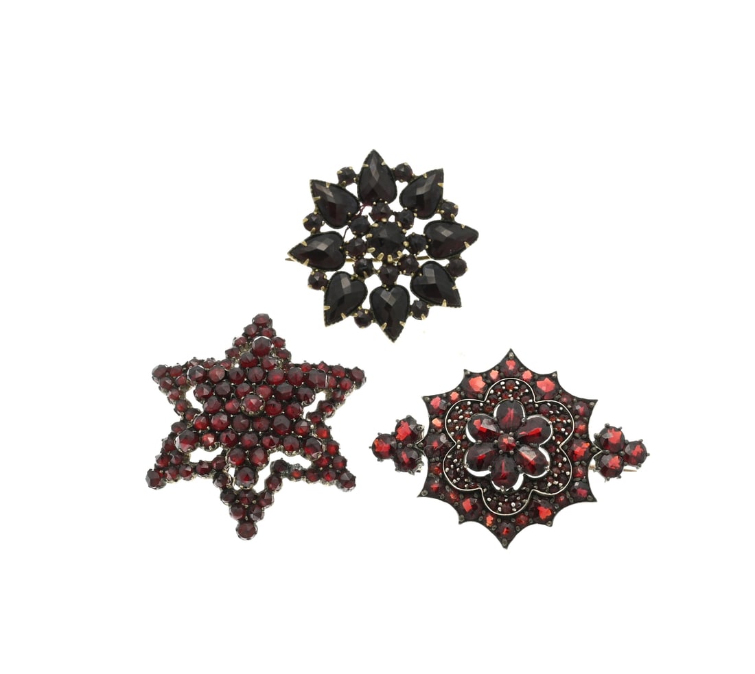 3 Brooches with garnet: Lot 3 with brooches with garnet, 2 double brooches in star shape and a silver gilded brooch in a marquise shape with garnet. 3-4,2cm. In good condition.