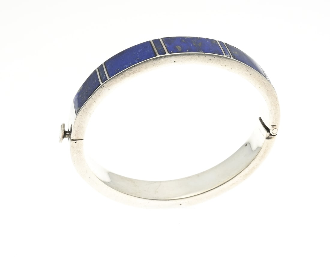 Silver bangle with lapis lazuli: Silver bangle, 925/000, rectangular tube, all around with lapis lazuli. Bracelet with hinge. width 11 mm. ø 62x55mm. approx. 44 grams. In good condition.