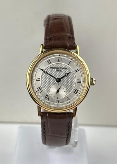 Frederique Constant watch: Beautiful Frederique Constant watch, ladies model, with a gold-plated case and a decorated dial with an off-centre second hand. ref. no.: 1062572 FC235X2S5/2S6. Attached to a brown leather strap. ø