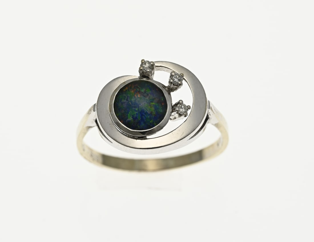 White gold ring with opal: White gold ring, 585/000, with opal and crystal. Ring with an openwork oval head set with a round setting with a blue opal and 3 settings with a small crystal stone. Width head 12 mm. ø 60. approx.
