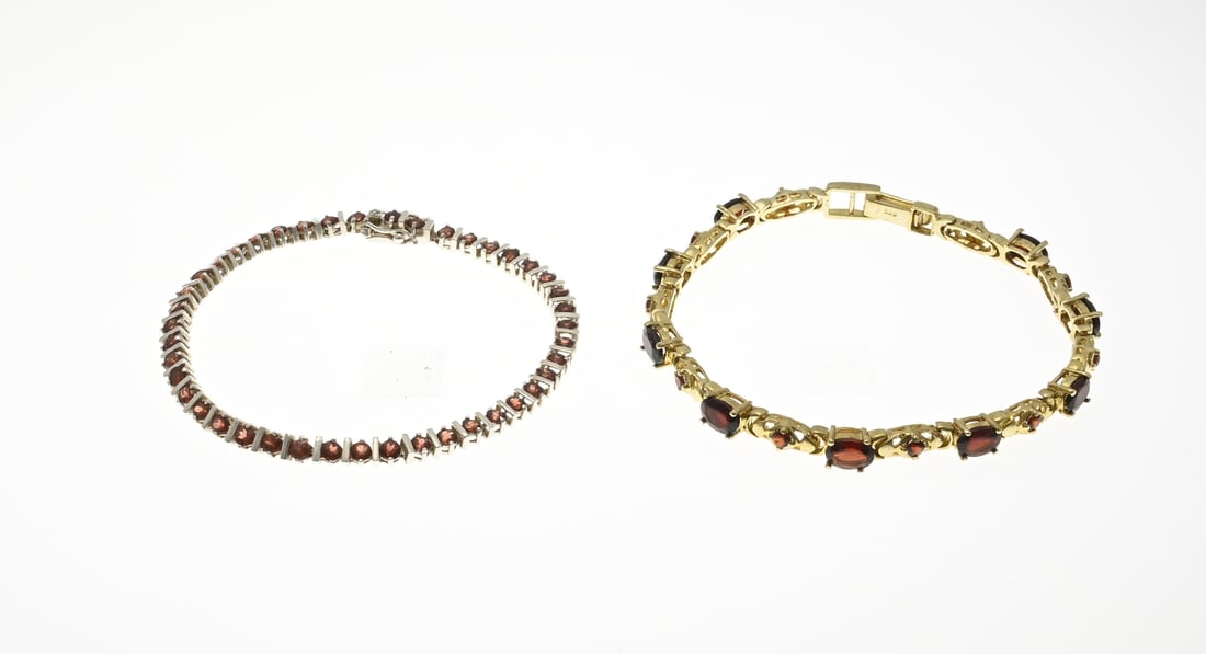 2 Bracelets with stones: Two bracelets, 925/000, with garnet stones. A silver tennis bracelet with bars between the stones. And a silver plated bracelet with oval and round faceted garnet stones. 18.5-19cm. Total approx.