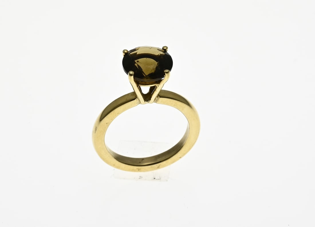 Gold ring with smoky quartz: Solid yellow gold ring, 585/000, with a high four-prong chaton, set with a round faceted smoky quartz, ø 10 mm. approx. 6.7 grams. ø 55. New.