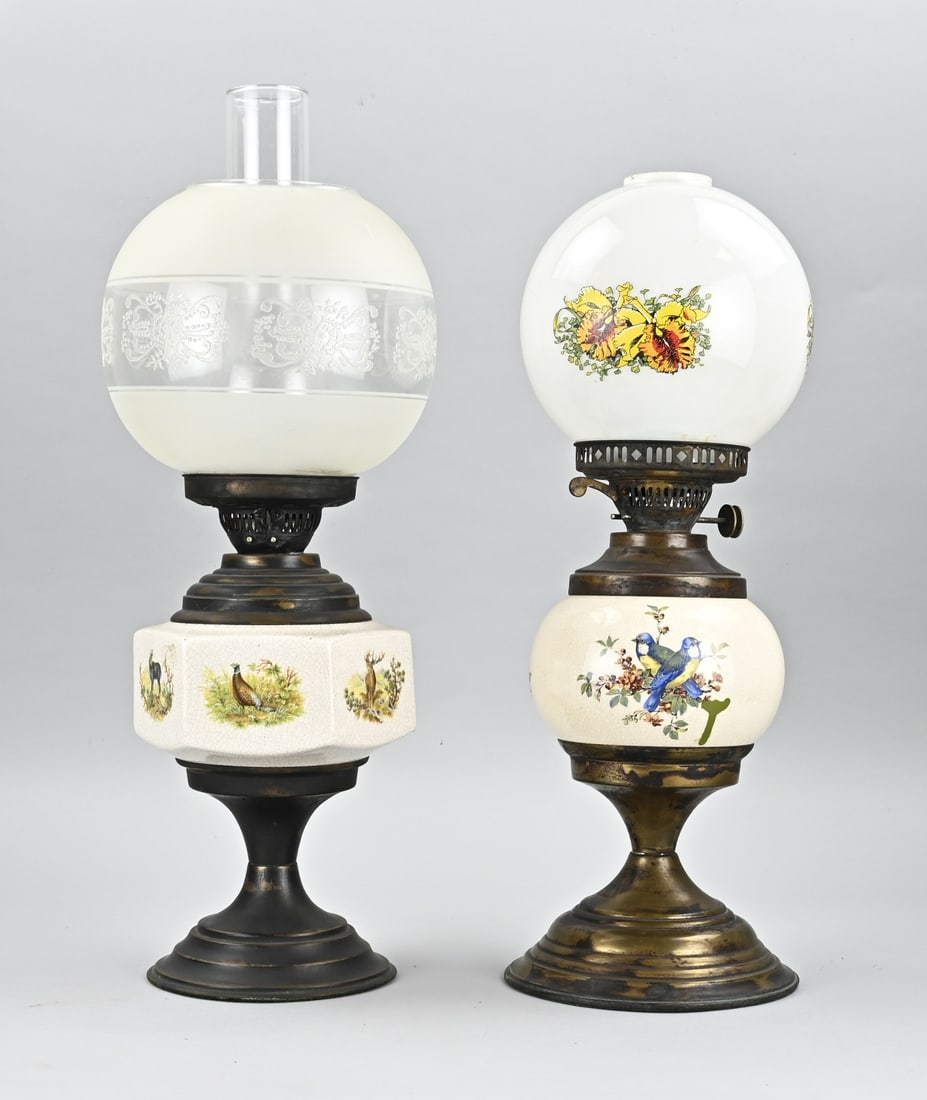 2x Kerosene lamp, H 51 - 56 cm.: Two old petroleum lamps with ceramic reservoir + game representation decor. 20th century. Dimensions: H 51 - 56 cm. In good condition.