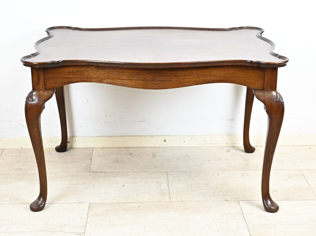 English coffee table: 19th century English mahogany coffee table with contoured top and queen Anne legs. Dimensions: 62 x 70 x 102 cm. In good condition.