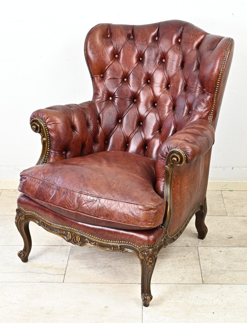 Leather chair, Chesterfield: Old leather Chesterfield chair with copper nails and carved wooden legs. 20th century. Dimensions: 97 x 88 x 95 cm. In good condition.