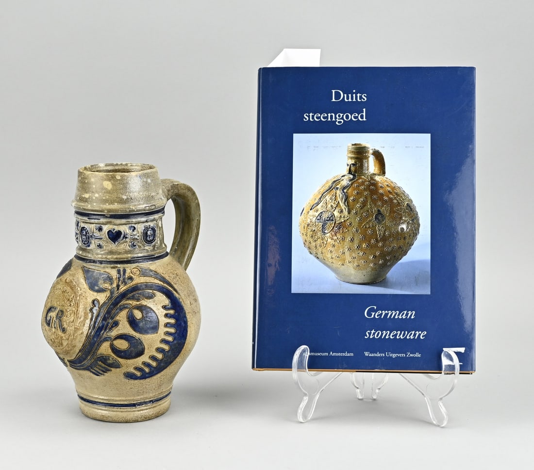 Stoneware jug + book 'German stoneware': 18th Century German Westerwald stoneware jug with initials GR For the English market. Circa 1750 for king George + book. Size: H 19,5 cm. In good condition.