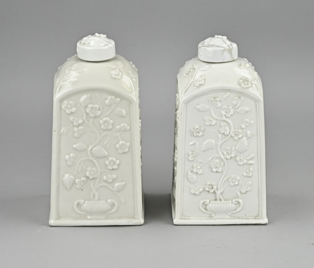 Set of white tea caddies (Saint Cloud): Two 18th century French white faience tea caddies from Saint Cloud. Floral decoration. With bottom mark. One lid glued. Size: 20 cm. In good condition.