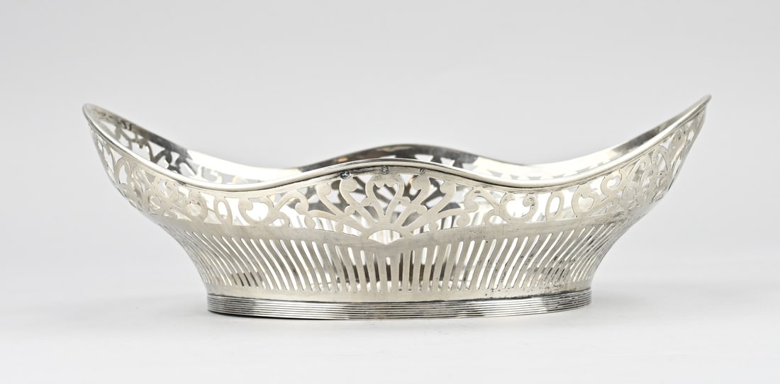 Silver bread basket: Silver bread basket, 833/000, oval model with a contoured edge. Sawn model with bars and floral decoration. Placed on an oval edge with double fillet work. MT.: fa. Niekerk, Schoonhoven, jl.:O:1949.