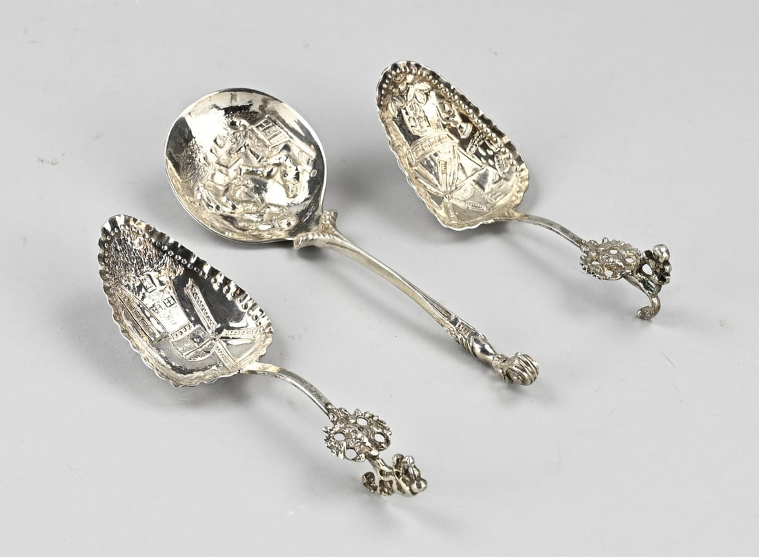3 Silver Cream Spoons: Lot with 3 silver cream spoons, 833/000. Two silver cream spoons with a scalloped bowl with a representation of a mill with a curled handle. One with a lion and one with a kaatser. MT.: J.Schijfsma,
