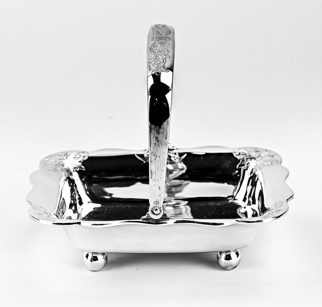 Silver candy basket: Silver bonbon basket, 835/000, rectangular model with a contoured edge decorated with Biedermeier engraving, placed on 4 ball feet and provided with a handle with Biedermeier engraving. 10x13x12cm.