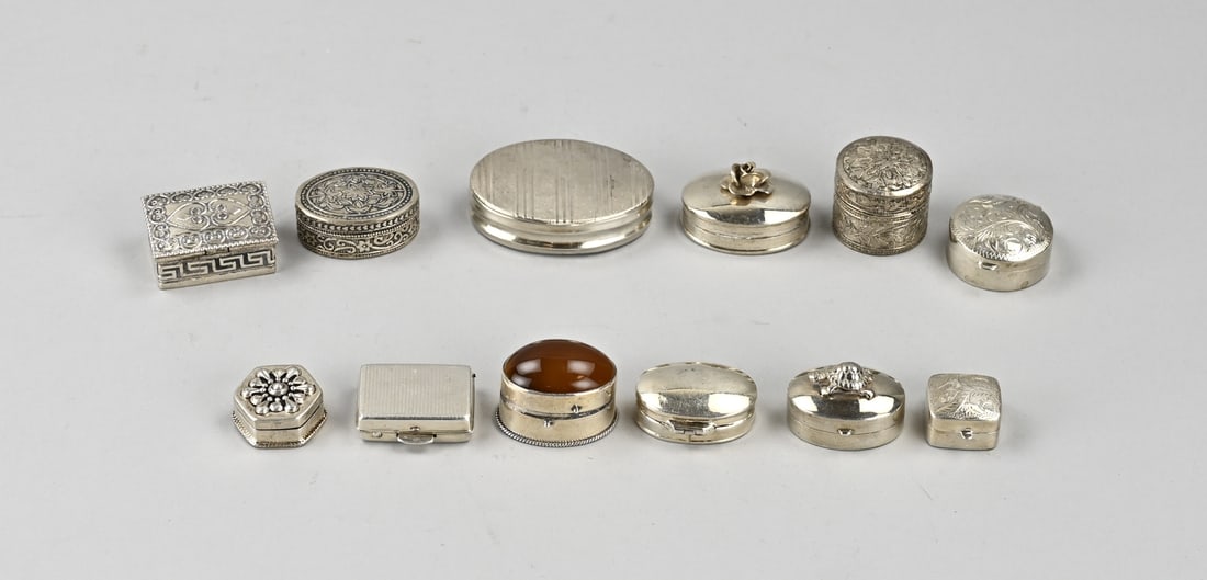 Lot of silver boxes (12x): Lot with 12 silver boxes, various models with various motifs, one with an agate stone. 2-5.5cm. Various grades. Total approx. 168 grams. In good condition.