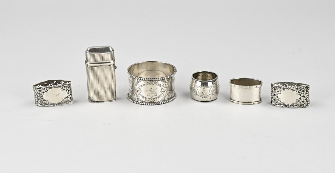 Lot of various silver: Lot silver with 4 finger cloths, a napkin band and a vesta with ribbed work. Partly provided with an engraving. Total approx. 127 grams. 2.8-5 cm. In good condition.