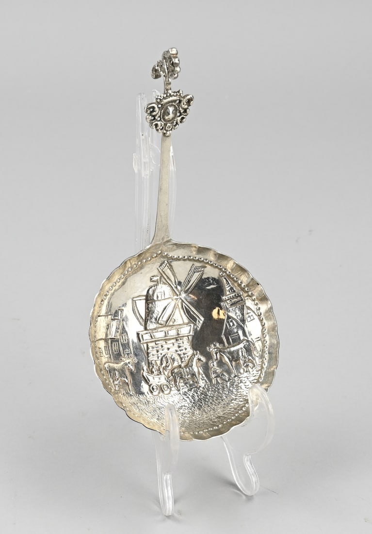 Silver cream spoon: Silver spoon, 800/000, with a large forged round bowl decorated with a representation of a mill, cityscape and animals. The bowl has a scalloped edge with pearl work. The handle with a curl is