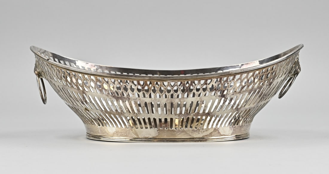 Silver bread basket: Silver bread basket, 835/000, oval model with a sawn bar decoration. The basket has 2 lion macrons with eyes as handles and is placed on an oval ring with double filet edge. 28x17x9cm. approx. 360