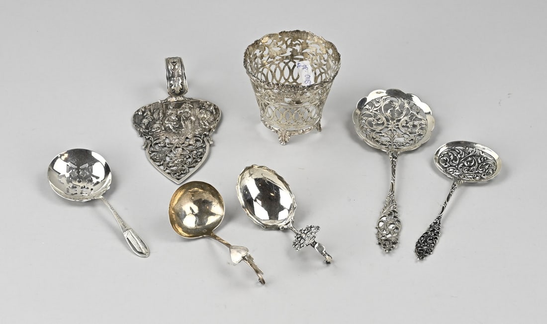 Lot of silver spoons, 7x: Lot with six parts of silver spoons and a holder, 2 cream spoons, 833/000, one with a round bowl and a curled handle with heart and swan element, MT.: J.Feenstra, Leeuwarden, jl.: V:1880, bowl