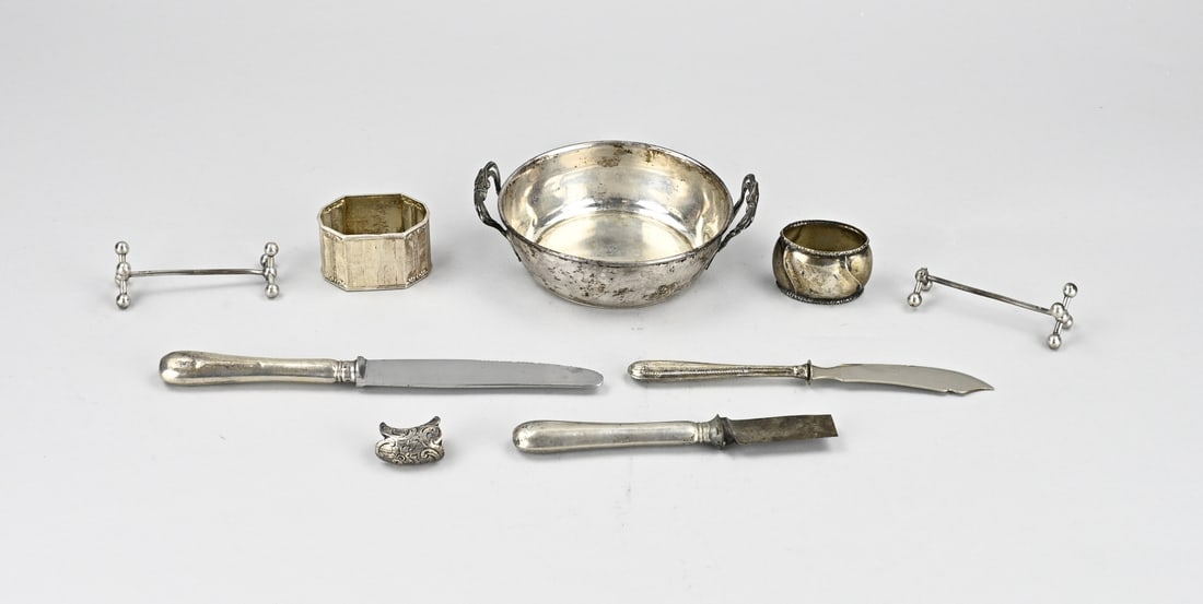 Lot of silver miscellaneous: Lot silver various with a bonbon basket with handle, one loose, 2 napkin bands, 2 knife rests, both defective, a pouring spout with engraving and 3 knives with silver handles. Various grades. Total