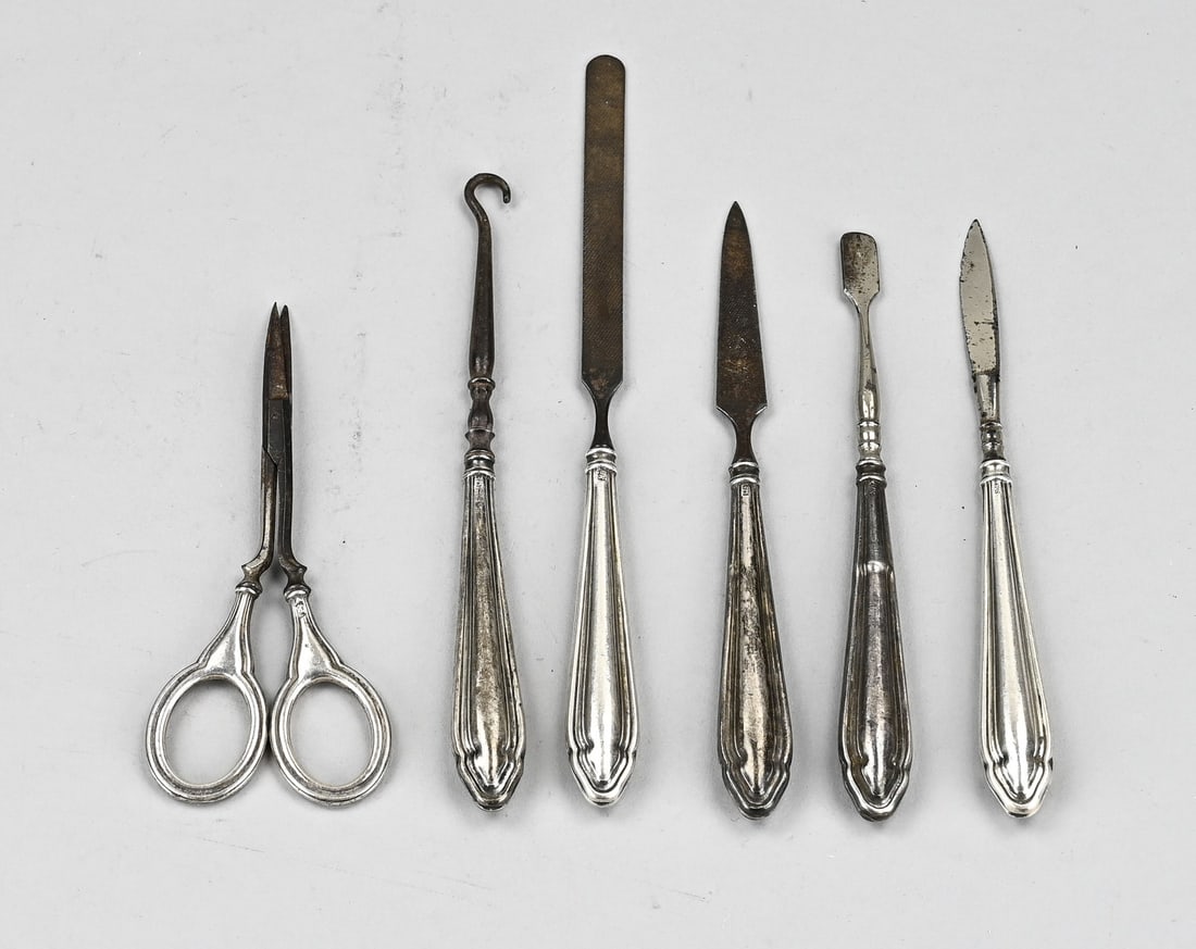 Silver manicure set: Manicure/ pedicure set, 6 pieces with silver handles, 925/000, contoured with filet edge, with scissors, 2 files, 2 nail knives and a hook. Total approx. 84 grams. In reasonably good condition.