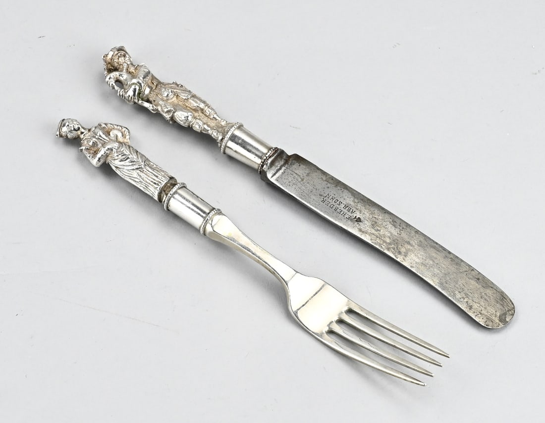 Antique travel cutlery: Travel set with silver. Travel cutlery with a knife and fork with handle in the shape of figures. Knife MT.: Johannes van Straten, Hoorn, 1894-1895. Fork H.Hooijkaas, Schoonhoven, jl.:N:1923. 20-21