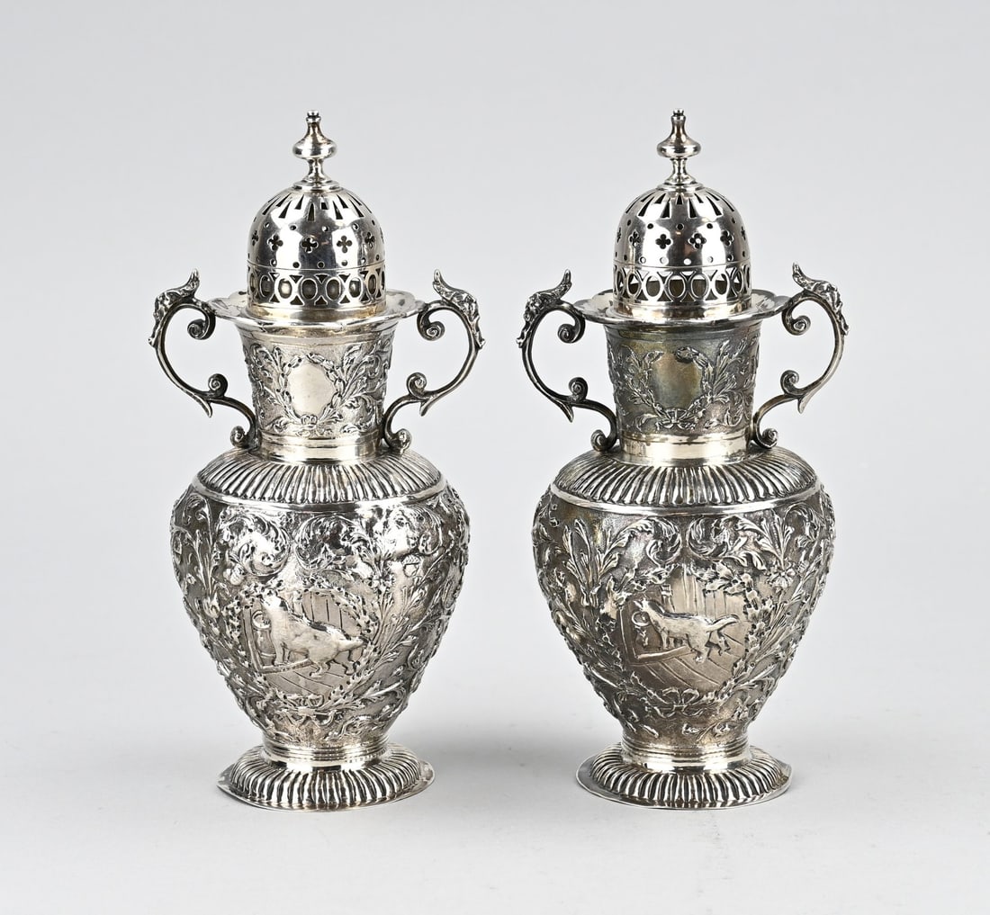 Two silver sprinklers: Set of 2 silver sprinklers, 934/000, placed on a round base with a knerren rim. The containers are decorated with floral decoration with representations of animals. With curled handles, a