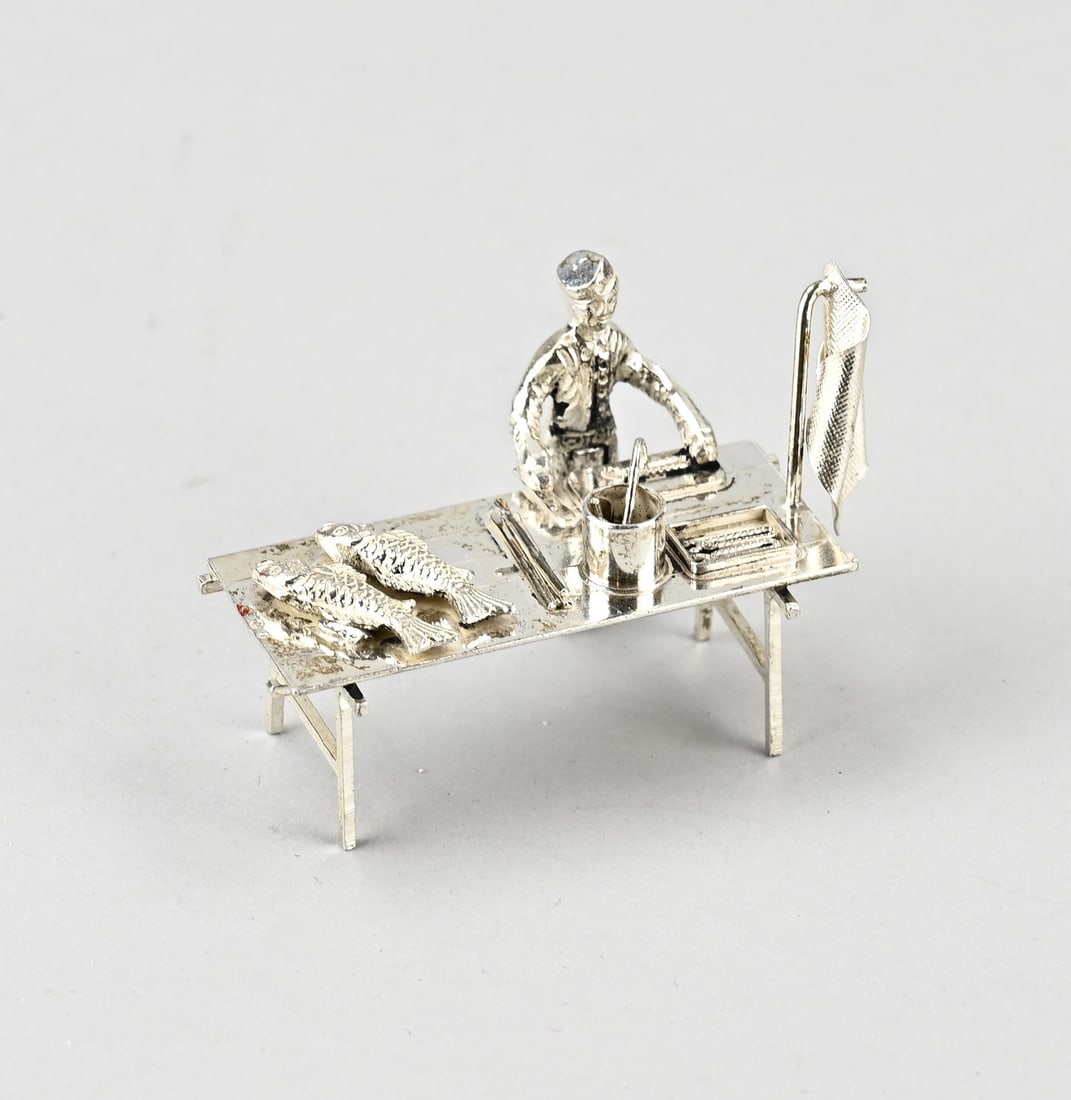 Silver miniature, fish stall: Silver miniature, 835/000, in the form of a fish stall with a figure, after an antique example. MT.: H.Hooijkaas, Schoonhoven, jl.:P1975. 6x2.5x4.5cm. approx. 40 grams. In very good condition