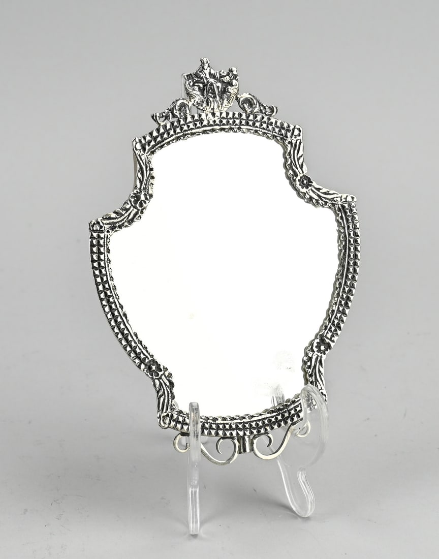 Hand mirror with silver rim: Hand mirror with silver rim, 833/000, made from a silver bag bracket with a worked rim and floral elements. The mirror has an element with figures. Equipped with a suspension eye. 17.5x12.5cm. In good