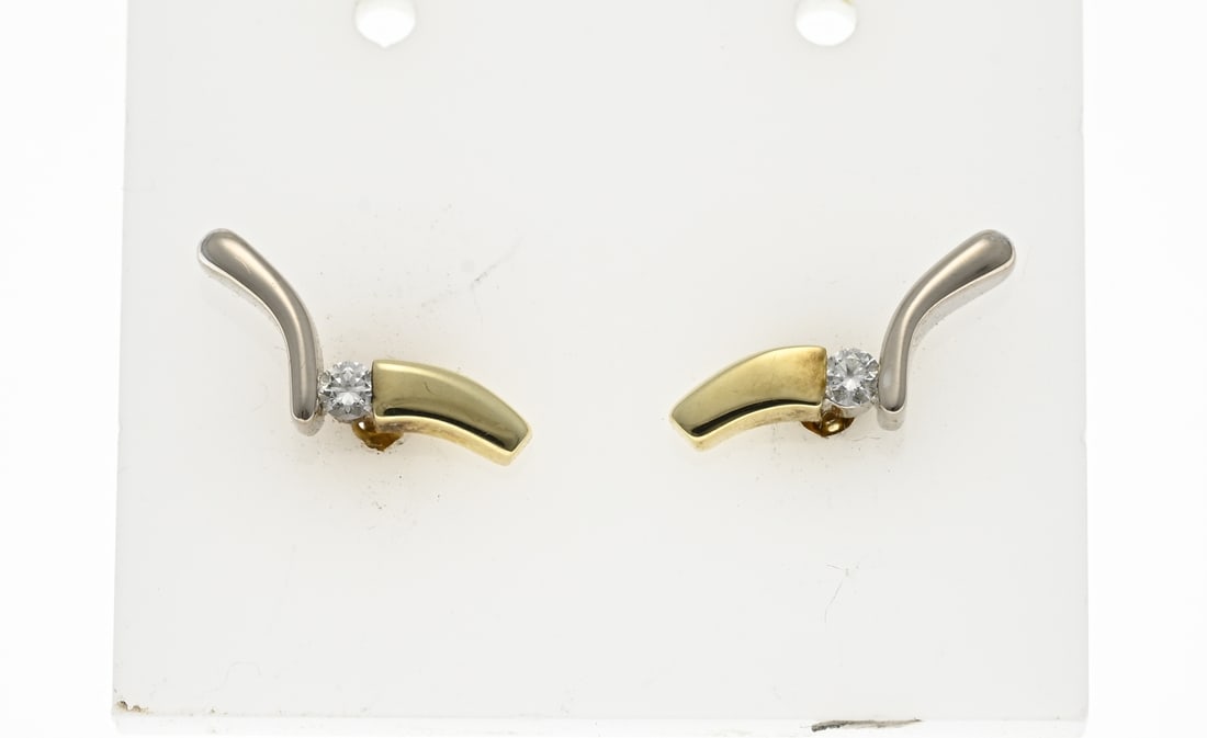 Gold stud earrings with diamonds, Diamonde: Yellow and white gold stud earrings, 585/000, with diamond. Stud earrings with a V-shape partly white and partly yellow gold with a brilliant cut diamond in between, total 0.06 ct, SI/W. 5x14mm.