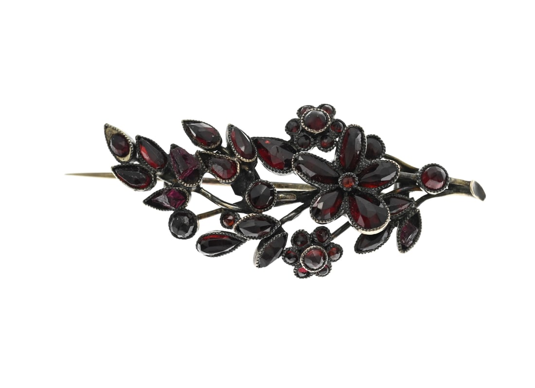 Gold brooch with garnet: Yellow gold brooch, 585/000, with garnet. Brooch branch model with flower elements set with various shapes of garnet stones. 4x2cm. approx. 3.9 grams. In good condition.