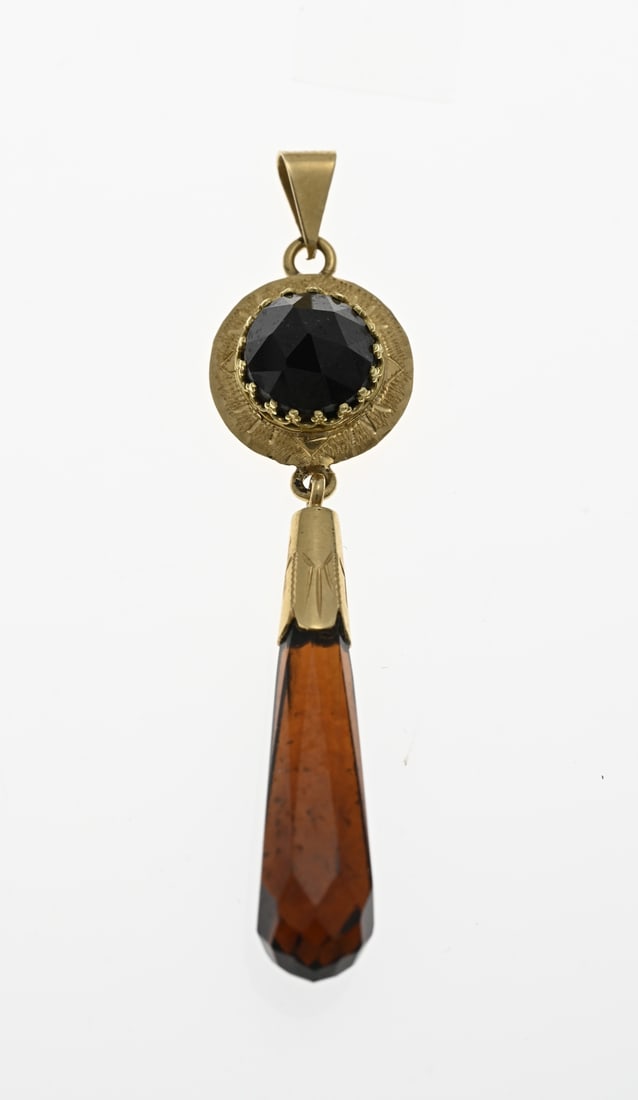 Long gold pendant with garnet: Yellow gold pendant, 585/000, with garnet. Long yellow gold pendant with a round element with a worked edge and set with a round faceted garnet stone. With a gold casing underneath with a peg-shaped