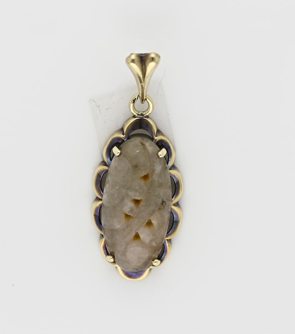 Gold pendant with carved jade: Yellow gold pendant, 585/000, with carved jade. Oval pendant with a scalloped edge and set with a beautifully carved jade stone with a light gray/brownish/green color. Pendant eye worn in. Length 39