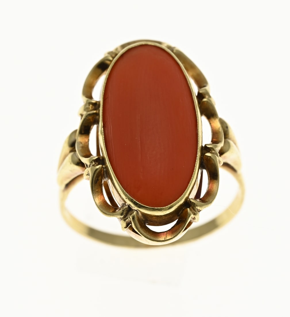 Gold ring with cut blood coral: Yellow gold ring, 585/000, with blood coral. Ring with an oval openwork head set with an oval cabochon cut blood coral. Width head 24.5 mm. ø 57. approx. 4.9 grams. In good condition